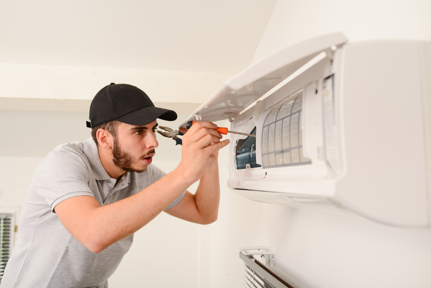 Technician repairing mini split AC unit in Easton, focusing on maintenance and troubleshooting.